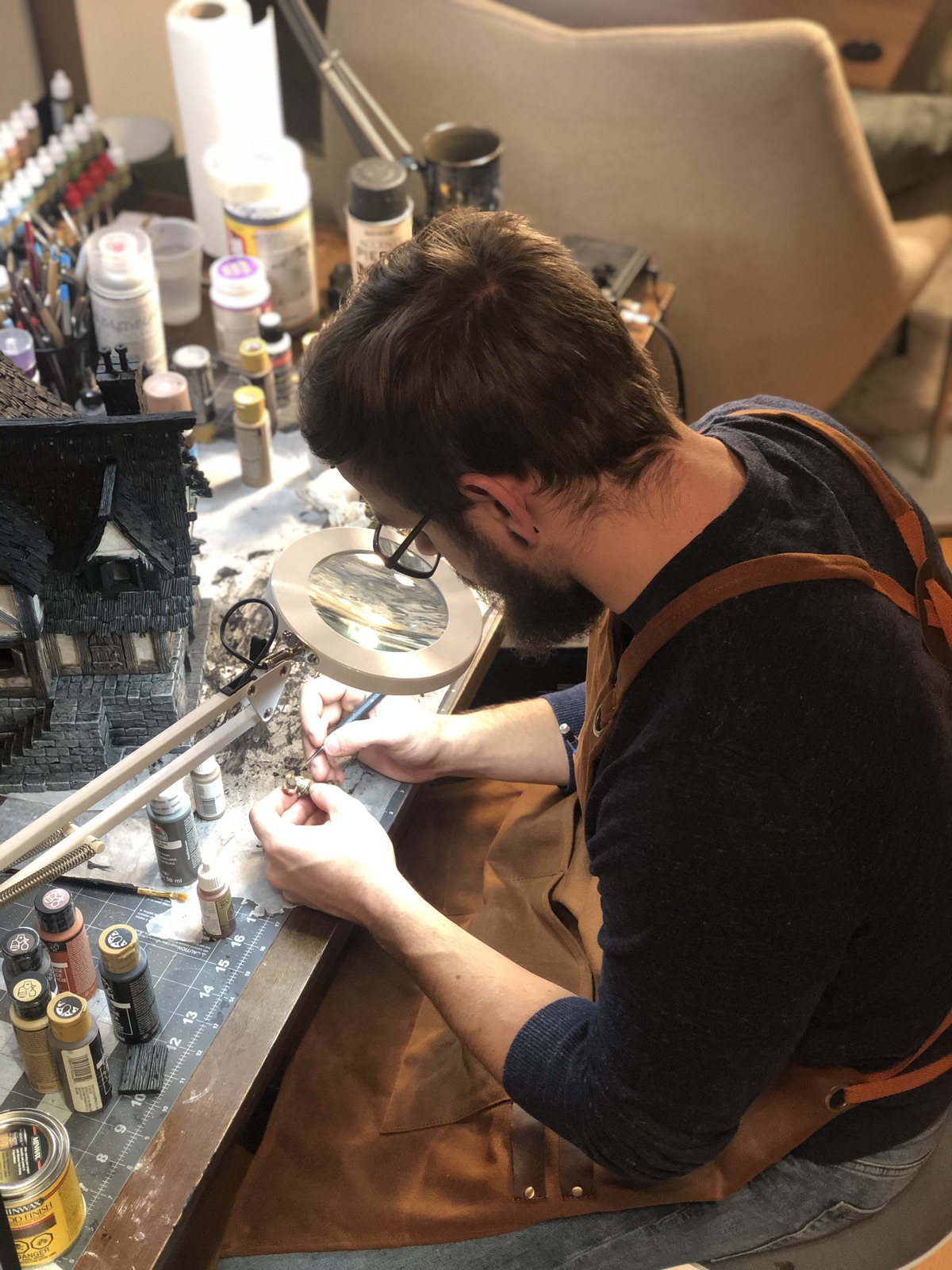 Nicholas at the workbench, painting a miniature.